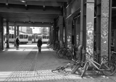 Photo noir et blanc représentant un passage sous voie où des vélos sont abandonnés. Artiste, Martes Martes. Lieu, Berlin.